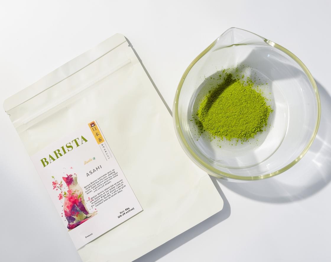 LISATA MATCHA Asahi barista grade green tea powder in a sealed pouch next to a glass bowl of vibrant matcha.