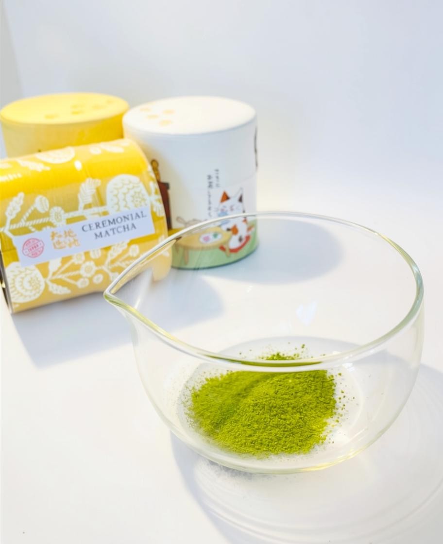 LISATA MATCHA ceremonial grade vibrant green matcha powder in a clear glass bowl with decorative reusable tins