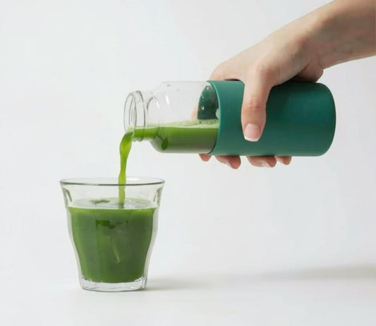 LISATA MATCHA REI cold brew matcha being poured from a green bottle into a glass for a smooth iced green tea drink